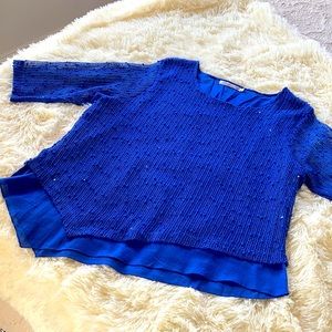 Sparkles on asymmetric hem with 3/4 sleeves.